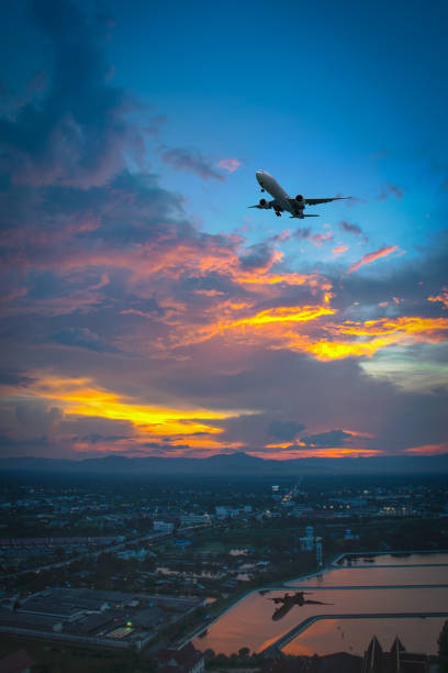 istock Silhouette of plane fly over sky and city during sunset. 808087800