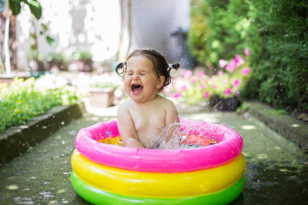 istock Baby splashing water in the pool 808102654