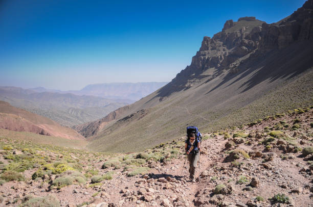 escursionista donna che cammina su un passo di montagna - atlas foto e immagini stock