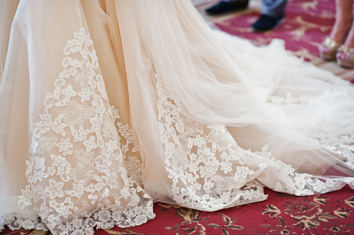 Fantastic close-up photo of wedding dress on a bride in a church.