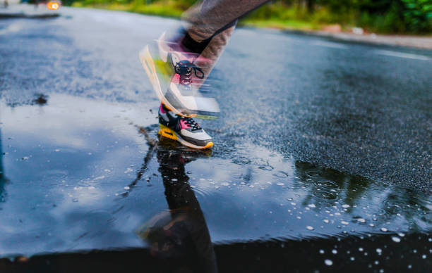 istock Girl jogging through puddles 808142166