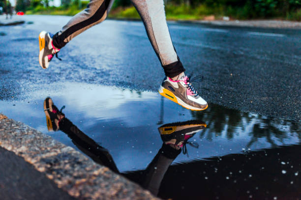 istock Girl running on wet road 808142364