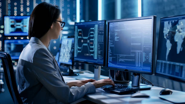 istock Female System Engineer Controls Operational Proceedings. In the Background Working Monitors Show Various Information. 808157266