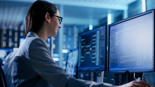 close-up shot of female it engineer working in monitoring room. she works with multiple displays. - center occupation headset on the phone imagens e fotografias de stock