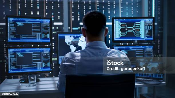 System Security Specialist Working At System Control Center Room Is Full Of Screens Displaying Various Information Stock Photo - Download Image Now