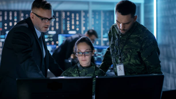 agência de vigilância do governo e operação militar conjunta. agente de masculino, femininos e masculinos oficiais militares, trabalhando no centro de controle do sistema. - military building - fotografias e filmes do acervo