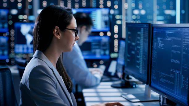 istock Female Engineer Controller Observes Working of the System. In the Background People Working and Monitors Show Various Information. 808157856