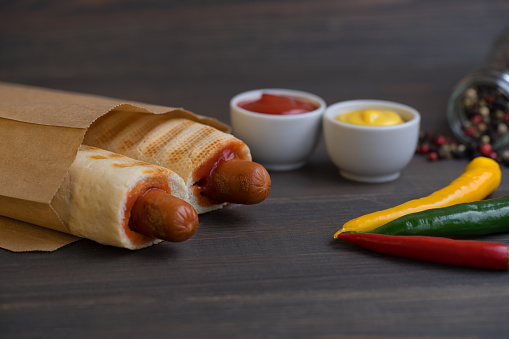 Barbecue Grilled Hot Dog with Yellow Mustard and ketchup on wooden table