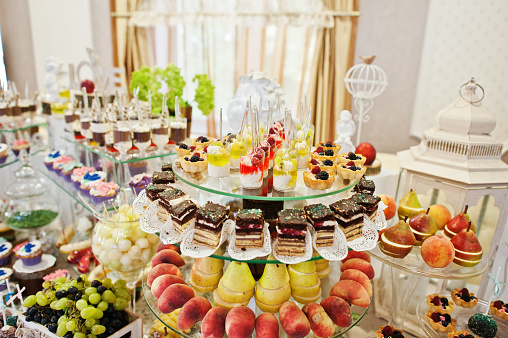Gorgeous-looking wedding table with various beverages, delicious dishes, fruits and decorations.