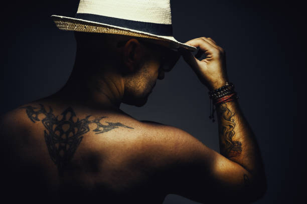 Naked Man With Hat Portrait of a naked man with tattoo on back and hand, wearing sun glasses and hat. arm tattoo ideas for men pictures stock pictures, royalty-free photos & images