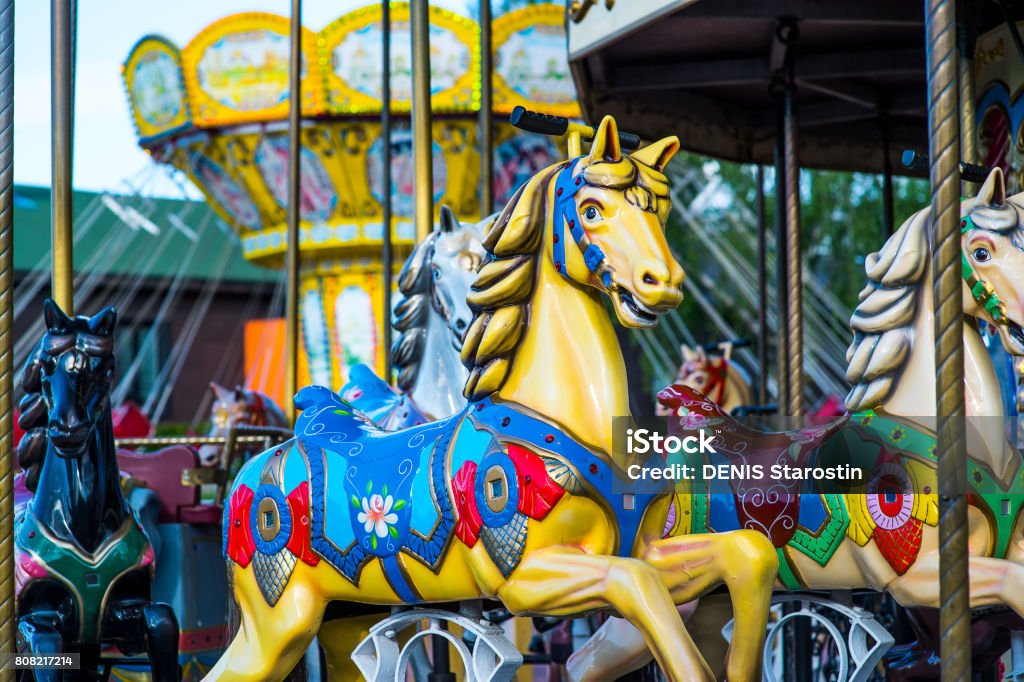 Beautiful horse Christmas carousel in a holiday park. Horses on a traditional fairground vintage carousel. Merry-go-round with horses. Beautiful horse Christmas carousel in a holiday park. Two horses on a traditional fairground vintage carousel. Merry-go-round with horses. Amusement Park Stock Photo