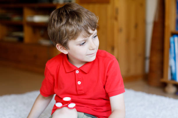 istock School kid playing with Tri Fidget Hand Spinner indoors 808217216