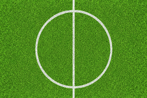 Green soccer field with white lines. Top view background