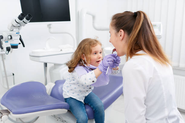 istock Little girl looking in dentist mouth 808327220