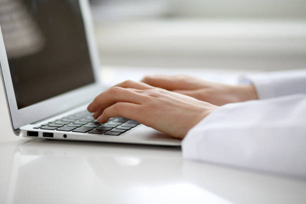 istock Female doctor typing on laptop, close up 808350668