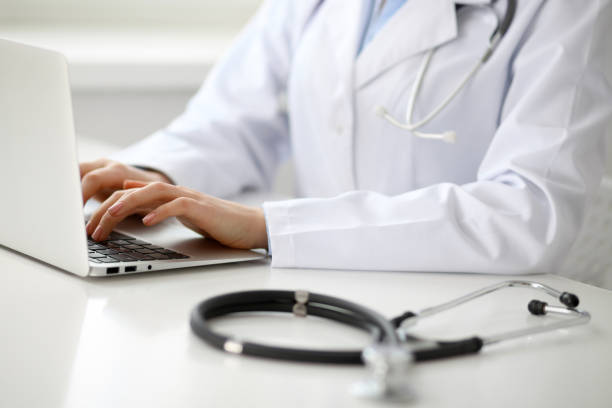 istock Female doctor typing on laptop, close up 808350778