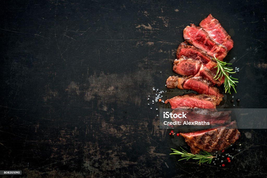 Sliced medium rare grilled beef ribeye steak Sliced medium rare grilled beef ribeye steak on dark background Meat Stock Photo