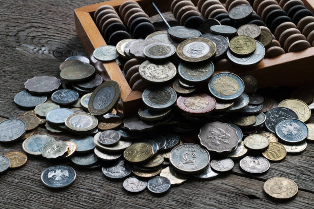 istock Pile of coins from different countries and wooden abacus 808365600
