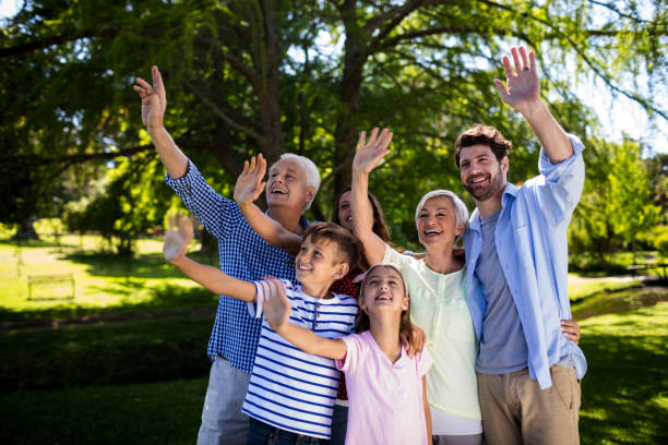 istock Multi generation family waving hand in air at the park 808369320
