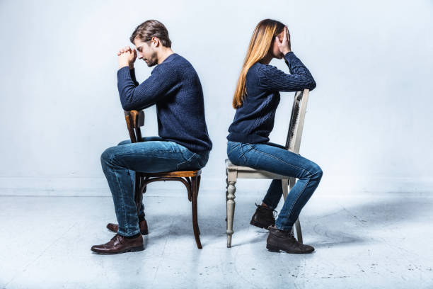 istock young couple sitting on chairs in opposite directions 808422652
