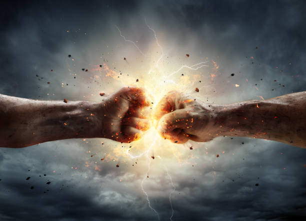 Conflict Concept - Two Fists In Impact Two Fiery Fists In Impact With Stormy Sky In Background rivalry stock pictures, royalty-free photos & images
