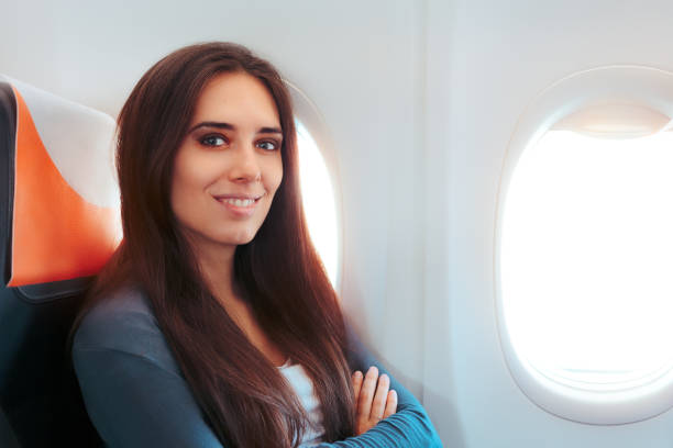 istock Smiling Woman Sitting By the Window on An Airplane 808435076