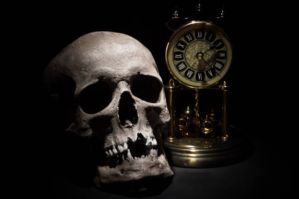 istock Human skull with vintage clock close up on black background 808444514