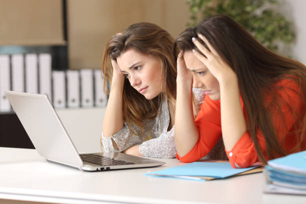 istock Sad coworkers watching content in a laptop 808456016