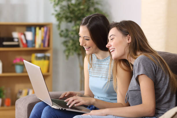 istock Two friends laughing watching media content on line 808470186