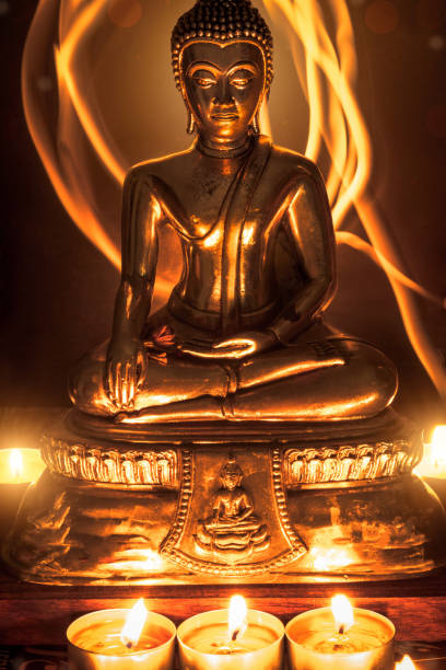 istock Selective focus of buddha statue with blurred burning candle light in soft night light. Concept of peace, meditation, hope and relaxation 808482934