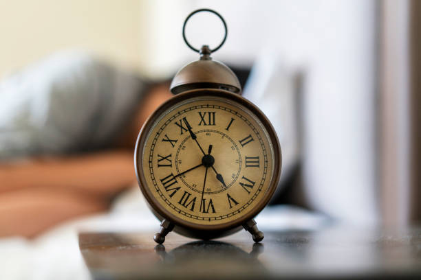 istock clock at bedside, girl sleeping on bed 808531608