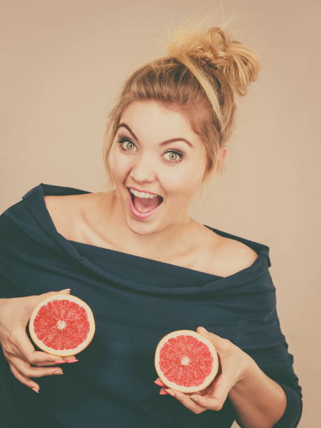 istock Woman holding red grapefruit on breast 808535382
