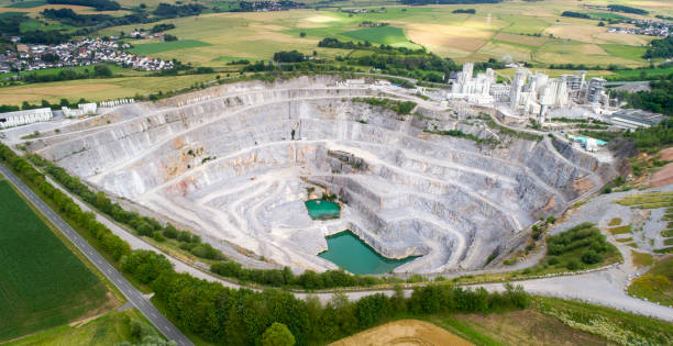 Aerial view of a large limestone quarry and industrial buildings Aerial view of a large limestone quarry and industrial buildings quarry stock pictures, royalty-free photos & images