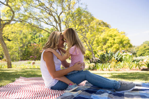 istock Happy mother embracing her daughter in park 808551454