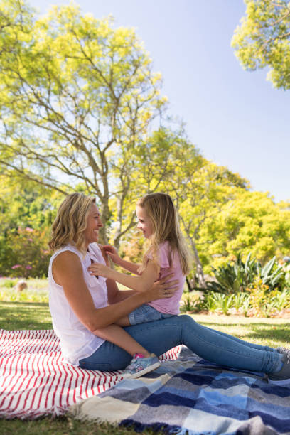 istock Happy mother embracing her daughter in park 808552424