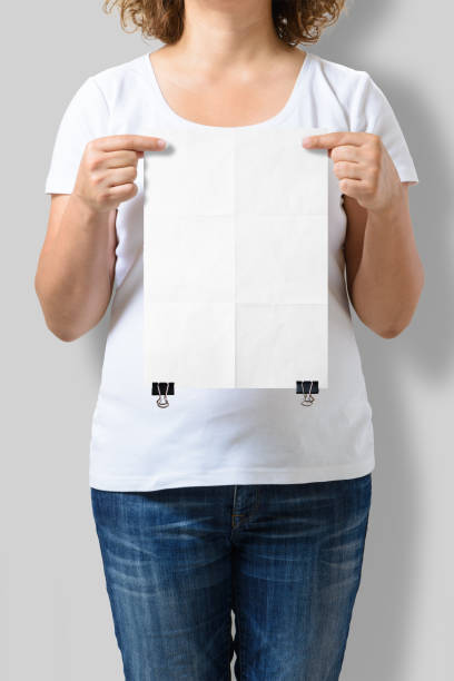 istock Woman holding a blank A4 poster mockup isolated on a gray background. 808560242