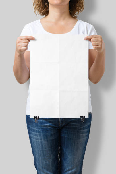 istock Woman holding a blank A3 poster mockup isolated on a gray background. 808562012