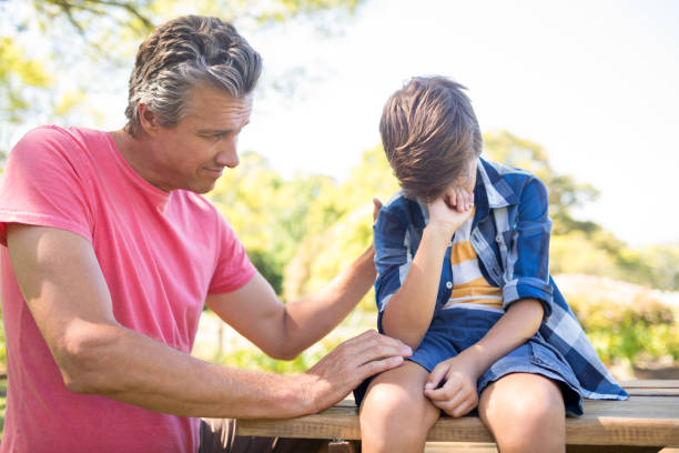 istock Father consoling his son at picnic in park 808565582