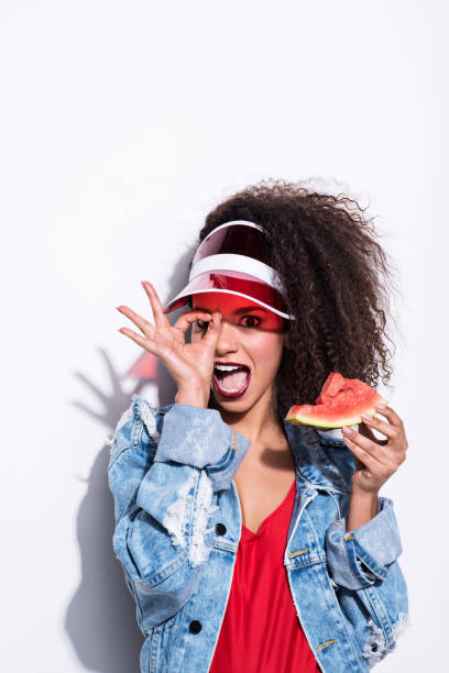 istock 80's style young summer woman eating watermelon 808567444