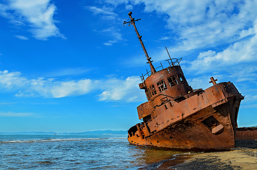 A rusty, stranded and sunken shipwreck vessel.