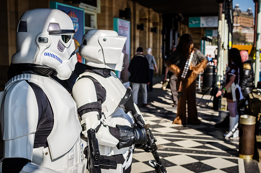 Cosplayers dressed as a 'stormtrooper' and a 'biker scout' from Star Wars pose outside Sci-Fi Scarborough with other cosplayers in the background.