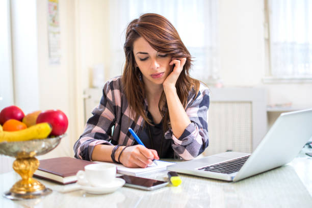 istock Young female student doing homework at home. 808657760