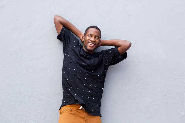 istock relaxed young african man standing with hands behind head 808669194