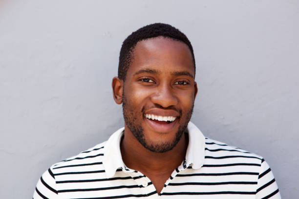 istock Close up cheerful african man smiling against gray wall 808669302