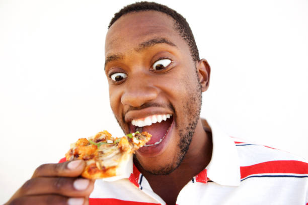 istock Excited young african man eating pizza 808669536