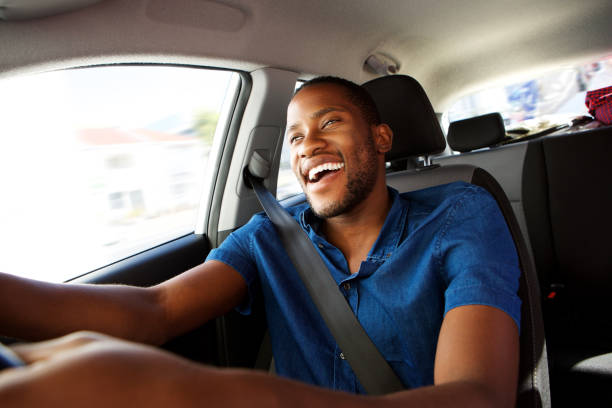 Young african man enjoying driving a car Portrait of happy young african man enjoying driving a car drivers seat stock pictures, royalty-free photos & images
