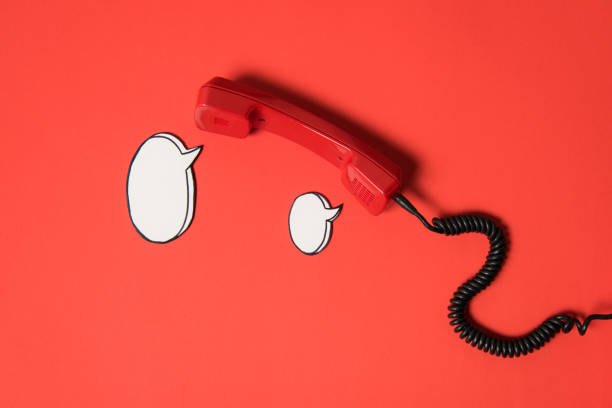 istock Traditional telephone receiver and blank speech bubbles isolated on red 808673144
