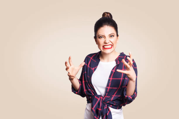 stressed and annoyed young casual styled caucasian woman Portrait of stressed and annoyed young casual styled caucasian woman with hair bun holding hands in mad furious gesture, screaming with ragea nd anger. Negative human emotions, facial expressions sulking stock pictures, royalty-free photos & images