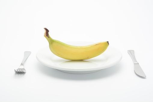 Raw banana in a plate on white background