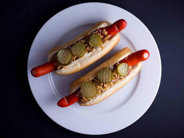 istock Two Danish hot dogs on plate, isolated on black background 808692720